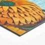 Vue zoomée sur le coin d'une photo imprimée directement sur une plaque d'aluminium dibond brossé et représentant une fleur orange