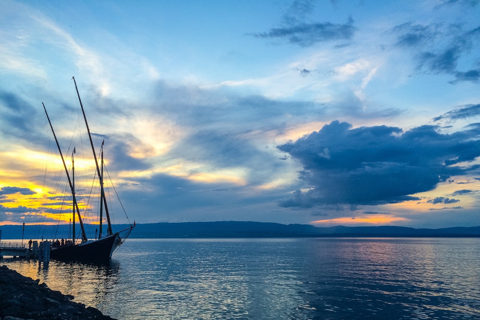 Un bateau accoste au bord du lac Léman au coucher du soleil
